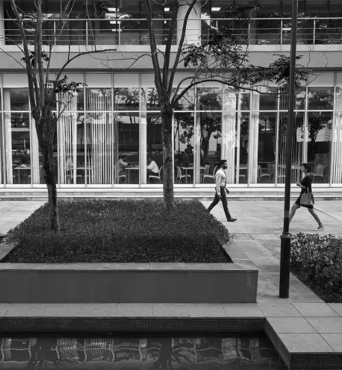 Two individuals walking outside the Candor TechSpace building in Newtown, Kolkata.